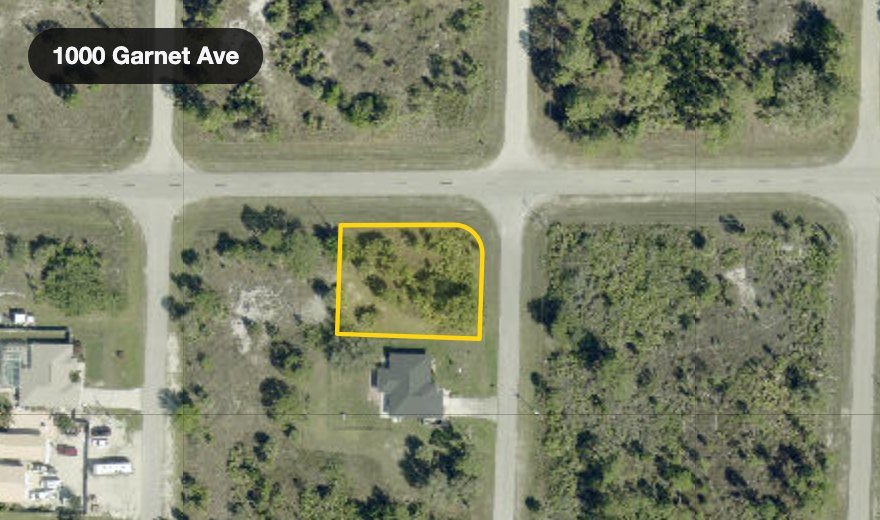 Satellite view of a vacant lot in Lehigh Acres with the county parcel boundary drawn over it